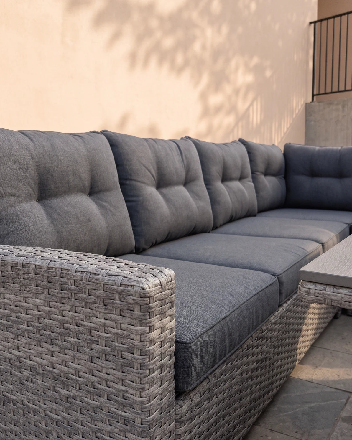 Close-up of the Atrico Lounge Set wicker corner sofa with tufted grey cushions and slatted coffee table