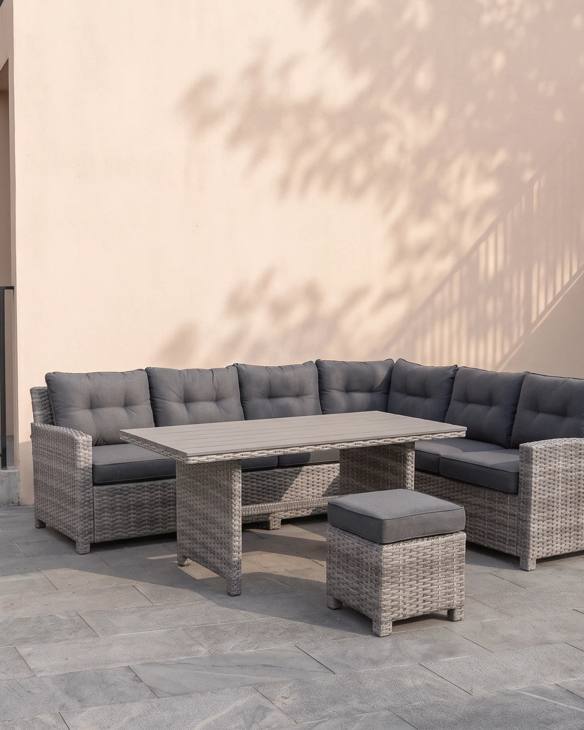 Atrico Lounge Set corner sofa, coffee table and stool on a modern villa terrace with a beige wall