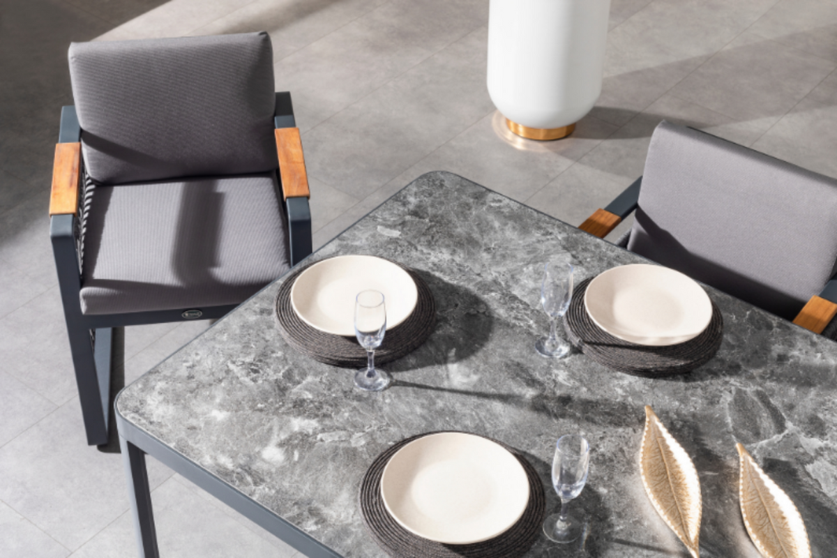 Terazzi dining table set for two with plates and glasses